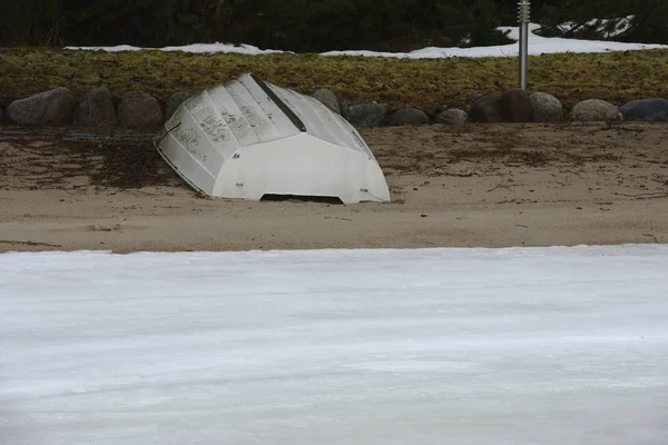 凍った湖の岸のビーチで白いボート — ストック写真