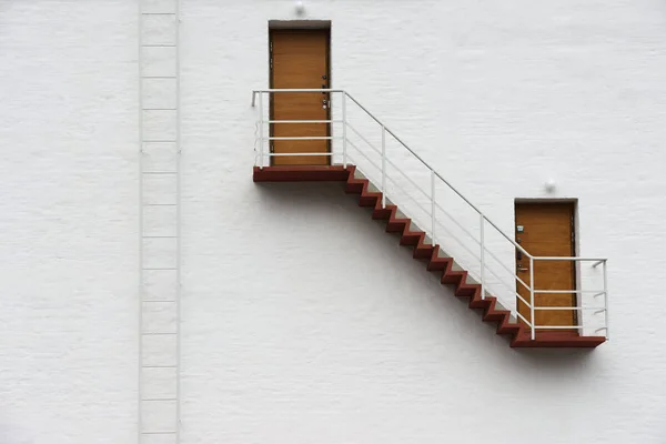 Witte muur met een trap en twee deuren — Stockfoto