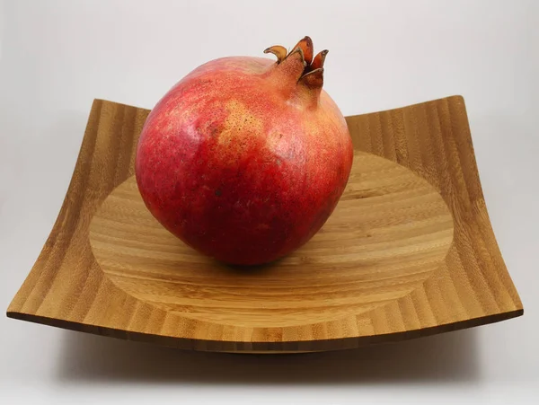 Zralý červený granátové jablko na dřevěném tácku — Stock fotografie