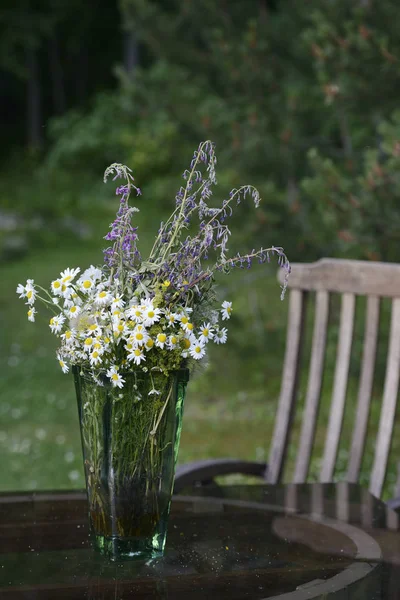 Buquê de flores silvestres em um vaso de vidro no jardim — Fotografia de Stock