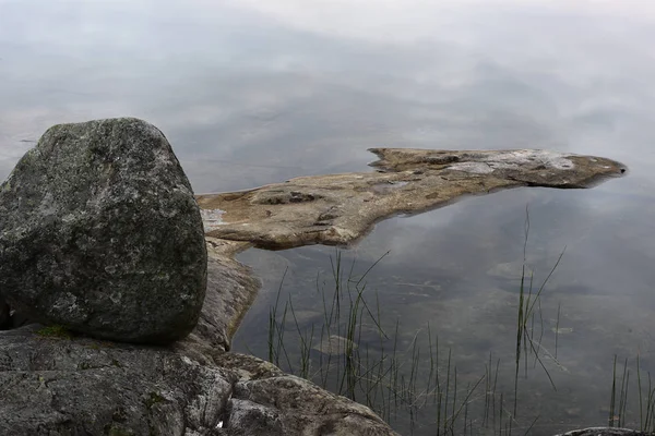 Stenen en rotsachtige oever van het meer in Finland — Stockfoto