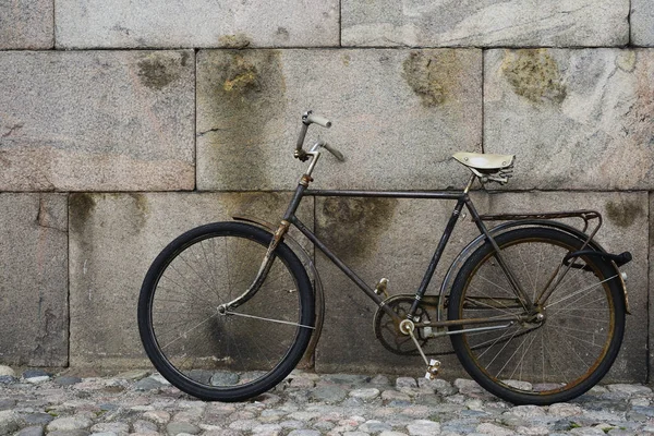 Old vintage bicycle by the granite wall — Stock Photo, Image