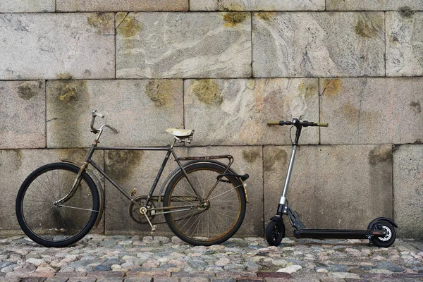 Old vintage bicycle and scooter against a granite wall in Helsin — Stock Photo, Image