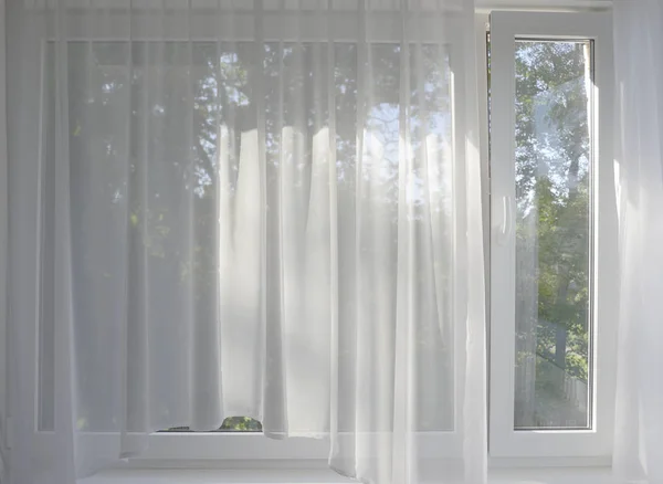Şeffaf perdelerarkasında pencerede bahçe — Stok fotoğraf