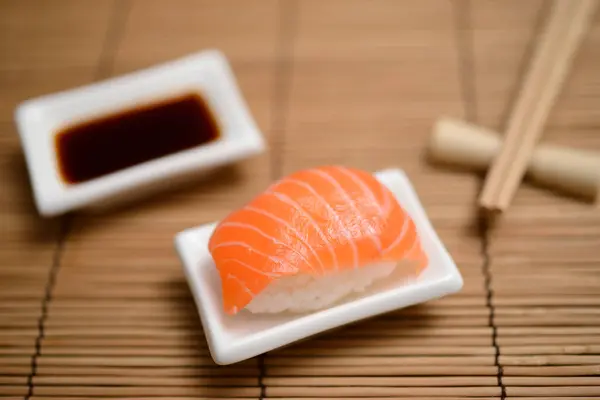 Essstäbchen Sojasauce Und Sushi Mit Lachs Auf Der Bambusmatte — Stockfoto