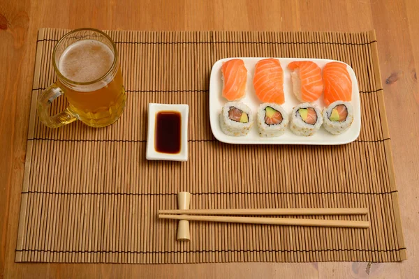 Essstäbchen Sojasauce Sushi Und Ein Glas Bier Auf Der Bambusmatte — Stockfoto