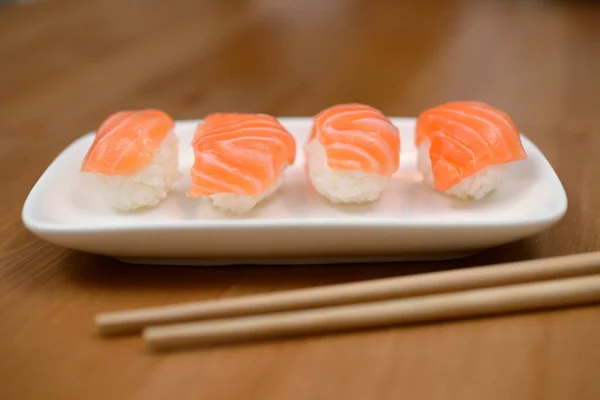 竹席上有鲑鱼的筷子和寿司 — 图库照片
