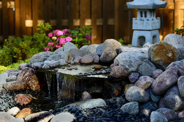石塔と小さな滝を持つ伝統的な日本庭園 — ストック写真