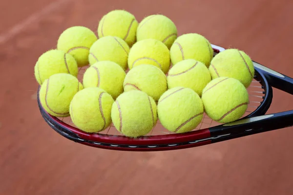 Raquette de tennis et balles sur le terrain d'argile — Photo