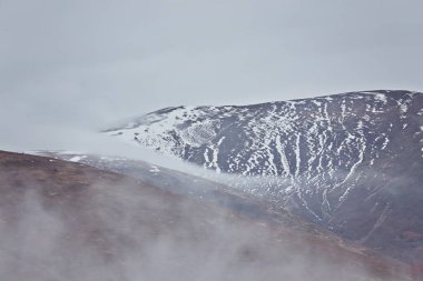 Sis dağlarda. Tepeler ağır bulutlar altında. Sessiz sonbahar manzara. Tepelerde kar.