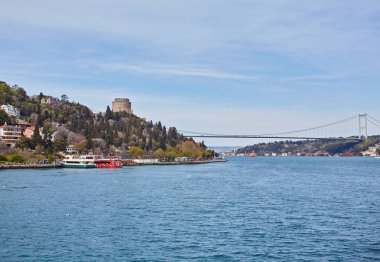 Geçen Boğaz Köprüsü boğaz boğaz arka plan ile arka plan bulutlu mavi gökyüzü ve Istanbul, Türkiye'de mavi deniz güneşli bir gemi. Türkiye kavramı mavi.