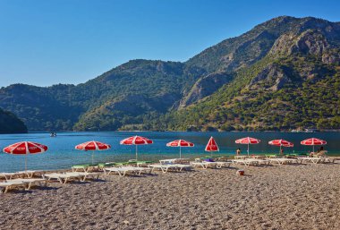 Blue Lagoon Ölüdeniz, Türkiye'de inanılmaz hava görünümünü. Deniz tükürük, yeşil ağaçlar, masmavi su, parlak güneşli bir günde kumlu plaj, yaz yatay. Arka plan seyahat. Milli Park üstten görünüm.