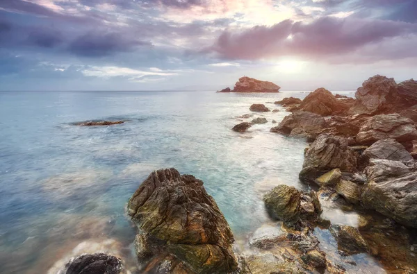 在塞浦路斯城邦海滩上的石头和岩石的奶油冲浪退潮和流动 背景中有更多的海岸线和 Troodos — 图库照片