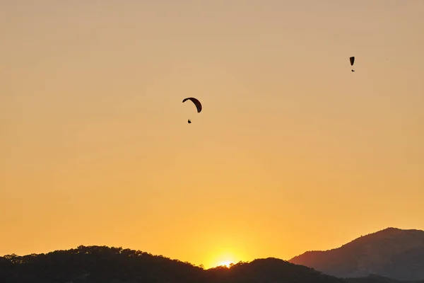 Zeegezicht Met Silhouetten Van Bergen Zee Bij Zonsondergang Paraglider Vliegen — Stockfoto