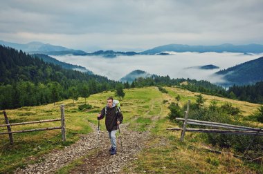 Adam, ağır sırt çantası seyahat yaşam tarzı ile günbatımı Dağları yolculuk tutkusu macera kavramı yaz tatillerini açık yalnız doğaya hiking