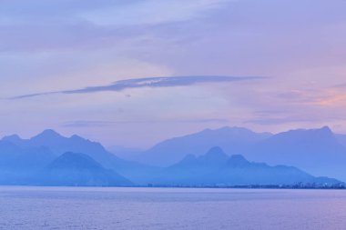 Akdeniz. Resort kasaba Kemer, Antalya, Türkiye'nin denizden görünümünü. Toros Dağları üzerinde günbatımı.