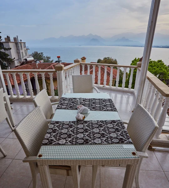 Konyaaltı bölgesinde popüler tatil şehir Antalya, Türkiye, mavi deniz kenarında uçurumun kenarında restoranda. Güneşli bir gün, ufukta yüksek dağlar