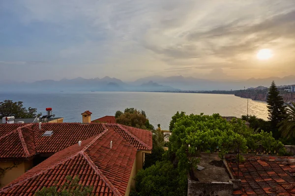 Seascape timelapse of high mountains over clear sunset sky in Antalya, Turkey. Sea and flowers on foreground.