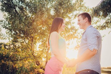 Mutlu çift tatilde. Aşık gülüyorlar. Mutlu erkek ve kız. Sevgili akşam parkta hoşlanıyoruz.