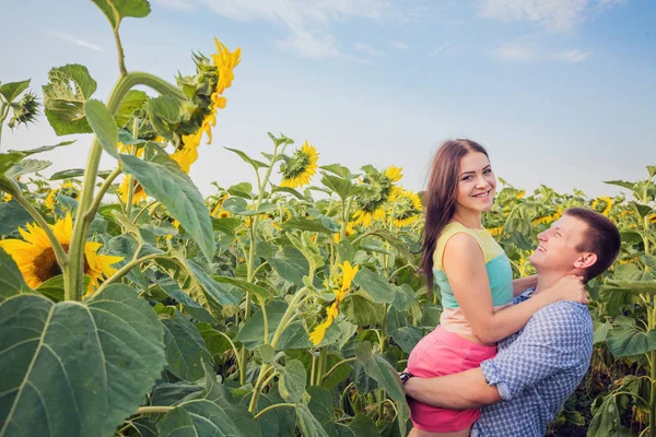 young girl and a young man in a field of sunflowers