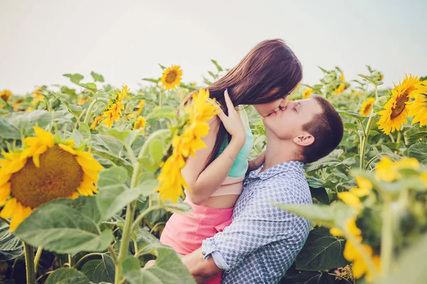 年轻的女孩和一个年轻的男人在向日葵的领域 — 图库照片