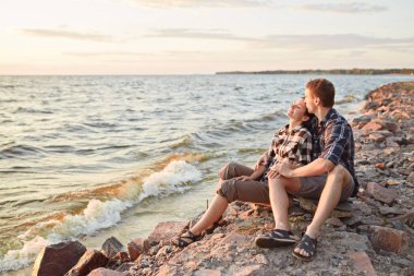 Romantizm ve aşk. Tanışma ve park. Seven birlikte göl yakınındaki çimenlerin üzerinde oturan Çift.