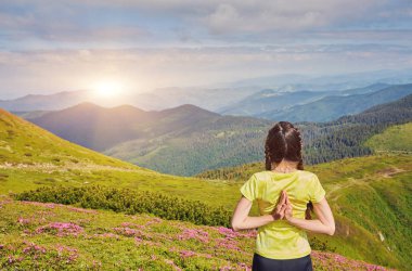 Güzel dağ manzarasında yoga egzersizi yapan genç bir kız. Gün doğumu, Namaste Lotus pozu. Meditasyon ve Rahatlama