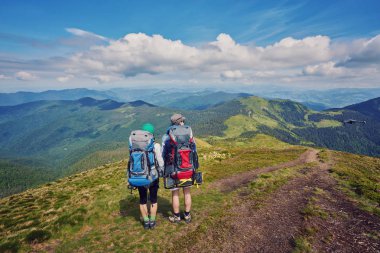 kaç yürüyüşçü günbatımı dağlar, seyahat ve açık macera kavramı panoramik zevk sırt çantaları ile