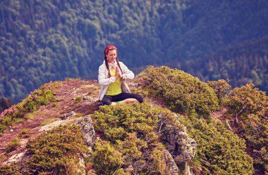Genç fitness kadın pratik yoga dağ tepe uçurumun kenarında