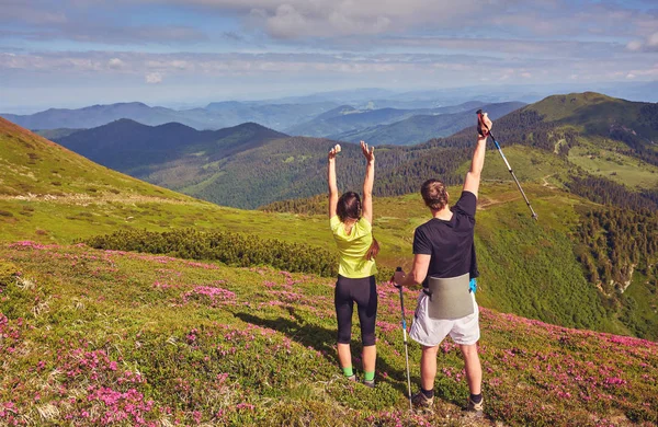 Birlikte merak dünya. Genç adam ve el ele tutuşarak, günbatımı karşı dağın tepesinde duran kız. İnsanlar, aşk, Doğa ve seyahat kavramı. Tonlu renkler. Eski stil fotoğraf