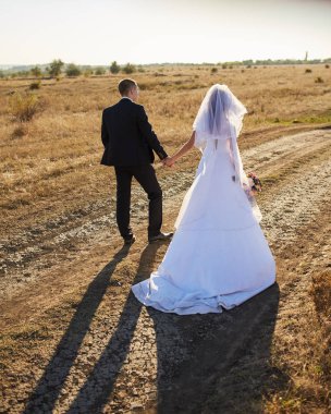 Gelin ve damat ile alan el ele gider. Mutlu gelin ve damat elele ve düğün gününde alanına yürüme.