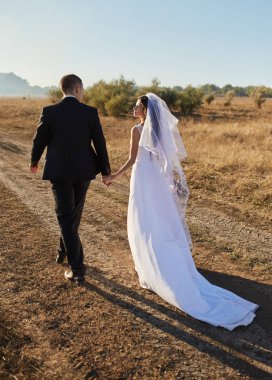 Gelin ve damat ile alan el ele gider. Mutlu gelin ve damat elele ve düğün gününde alanına yürüme.