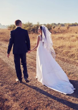 Gelin ve damat ile alan el ele gider. Mutlu gelin ve damat elele ve düğün gününde alanına yürüme.