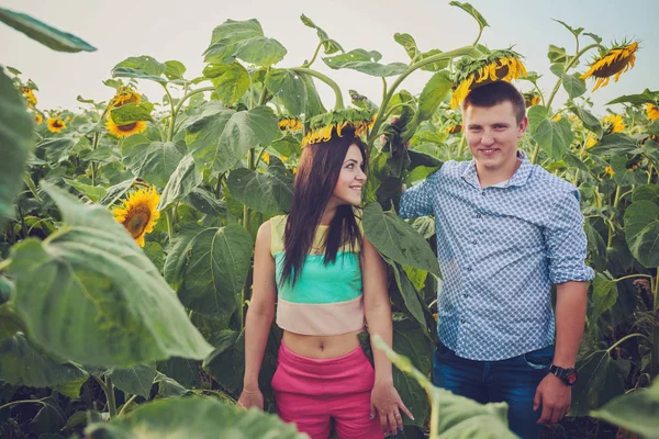 Mädchen und Mann in einem Sonnenblumenfeld — Stockfoto