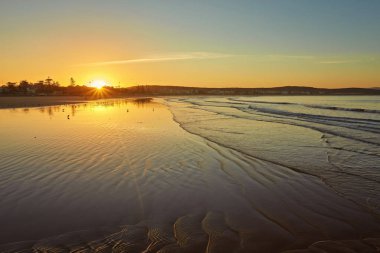 Martılar, su yansımaları ve yel değirmenleri ile sığ derinlik-in tarla Essaouira, Fas zemin üzerine sahilde romantik günbatımı