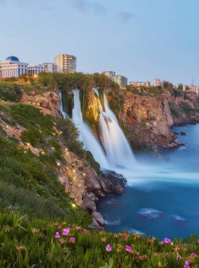Antalya Akdeniz'de içine platformdan basamaklı su gece manzarası. Illuninated alt Düden şelale popüler sahil resort City Antalya, Türkiye.