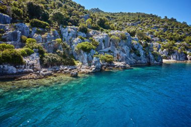 Kekova batık şehir Antalya Kastamonu ilinin turqouise deniz kaya ile ve yeşil çalılar ile denizden Uchagiz bay görünümünde antik kentin su altında görünür kalır.