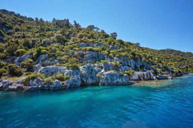 Kekova batık şehir Antalya Kastamonu ilinin turqouise deniz kaya ile ve yeşil çalılar ile denizden Uchagiz bay görünümünde antik kentin su altında görünür kalır.