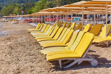 Şemsiye ve boş plaj sandalyeleri yakınındaki mavi deniz suyu, Kemer, Türkiye, Akdeniz sahilde.