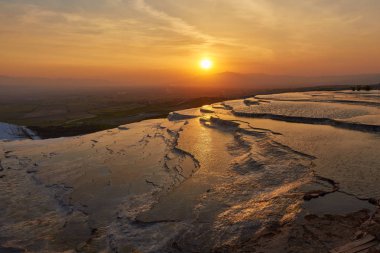 Güzel gündoğumu ve doğal Traverten havuzları ve teraslar halinde Pamukkale. Güneybatı Türkiye'de pamuk Kalesi,