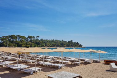 Mavi suya yakın sahilde boş plaj sandalyeleri, Kemer, Türkiye, Akdeniz.