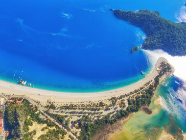Blue Lagoon Ölüdeniz, Türkiye'de inanılmaz hava görünümünü. Deniz tükürük, yeşil ağaçlar, masmavi su, parlak güneşli bir günde kumlu plaj, yaz yatay. Arka plan seyahat. Milli Park üstten görünüm.