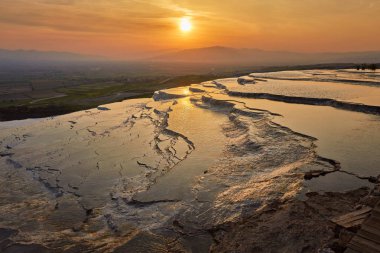 Güzel gündoğumu ve doğal Traverten havuzları ve teraslar halinde Pamukkale. Güneybatı Türkiye'de pamuk Kalesi,