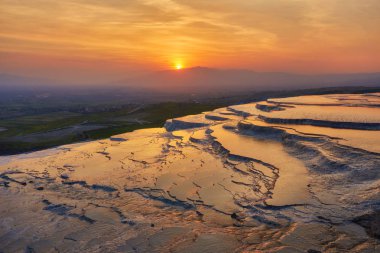 Güzel gündoğumu ve doğal Traverten havuzları ve teraslar halinde Pamukkale. Güneybatı Türkiye'de pamuk Kalesi,