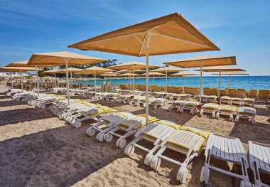 Şemsiye ve boş plaj sandalyeleri yakınındaki mavi deniz suyu, Kemer, Türkiye, Akdeniz sahilde.