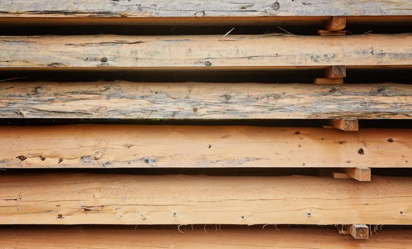 Wooden boards, lumber, industrial wood, timber. Building bar from a tree and an edging board in stacks.