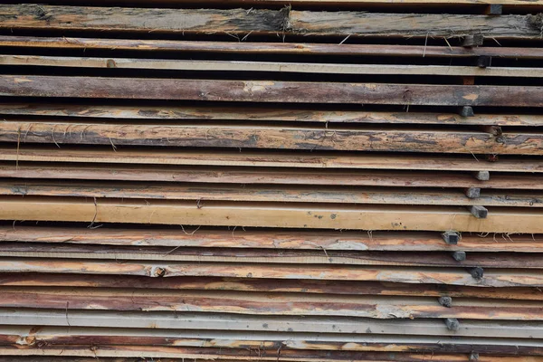 Wooden boards, lumber, industrial wood, timber. Building bar from a tree and an edging board in stacks.