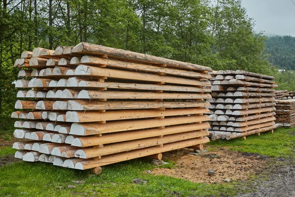 Wooden boards, lumber, industrial wood, timber. Building bar from a tree and an edging board in stacks.