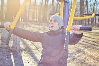 Adam parkta bir spor simülatörü yle meşgul.