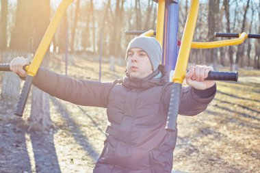 Adam parkta bir spor simülatörü yle meşgul.
